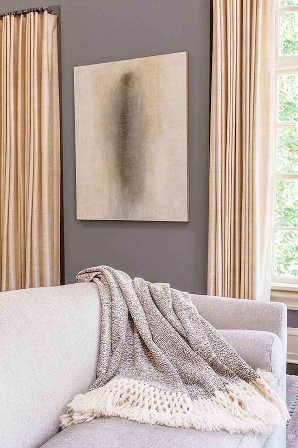 NEUTRAL TONES | A hand-woven salt-and-pepper Peruvian throw with oversized fringe echoes the soft natural tones in the atmospheric oil painting by New York City artist Louise Crandell.