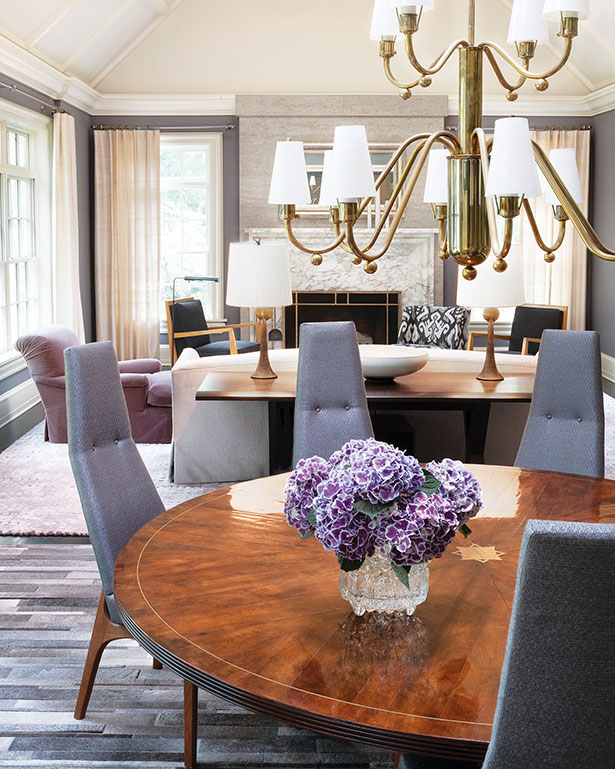 Vintage dining room chairs by Adrian Pearsall, newly upholstered in silver metallic fabric, surround a high-cut mahogany marquetry table that has a centered brass star fillet and expands to seat 12.
