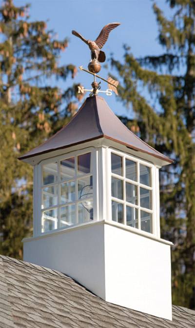 The cupola on the garage features a copper top with a weathervane.