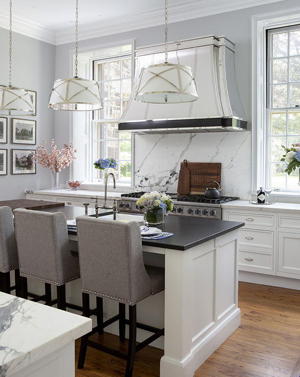 The homeowner selected classic marble for the kitchen backsplash and perimeter countertops and leathered Black Absolute granite for the island as a more “user-friendly work surface,”